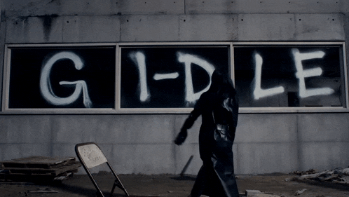 a person walking in front of a sign that says g1-dle