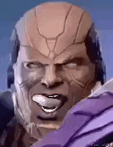 a close up of a man 's face with a helmet on and his tongue out .