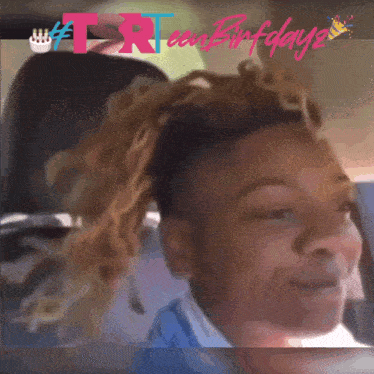 a girl in a blue shirt is smiling in front of a birthday card