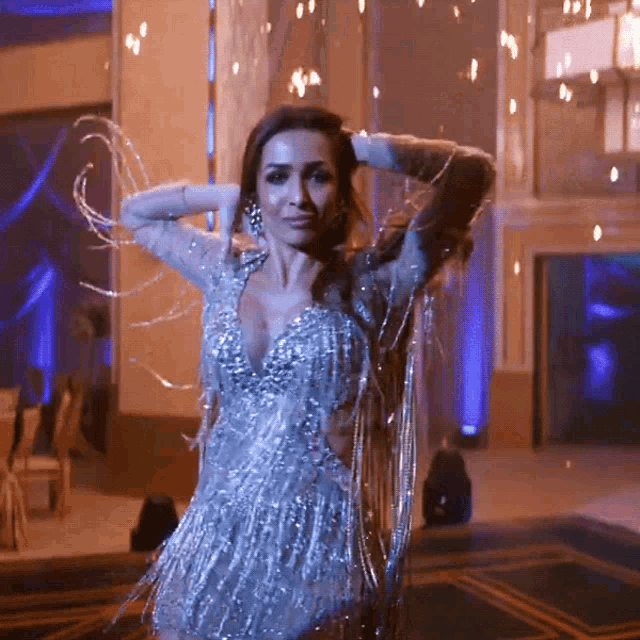 a woman in a dress with fringe is dancing in a room