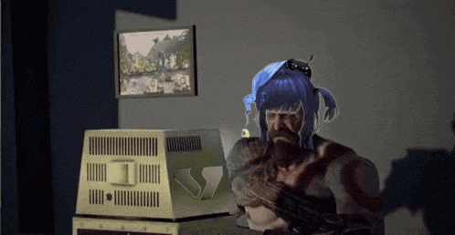 a man with a beard and blue hair is sitting in front of a television