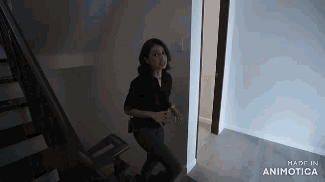 a woman in a black shirt is walking down a set of stairs in a dark room made in animatica