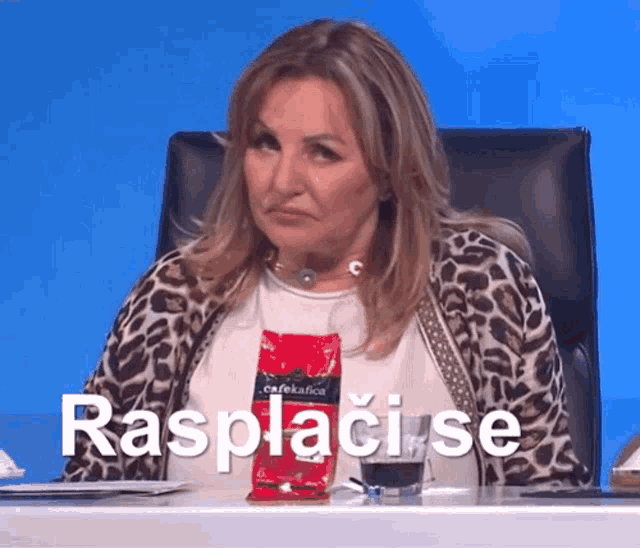 a woman in a leopard print sweater sits at a table with a bag of cafekafica coffee on it