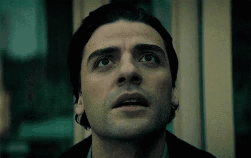 a close up of a man 's face with his eyes looking up .