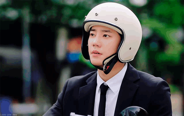 a man in a suit and tie is wearing a white helmet ..