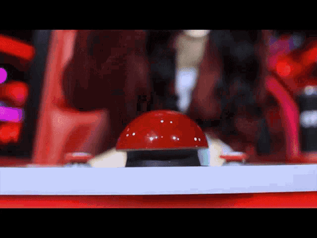 a red button with white dots on it is on a white surface