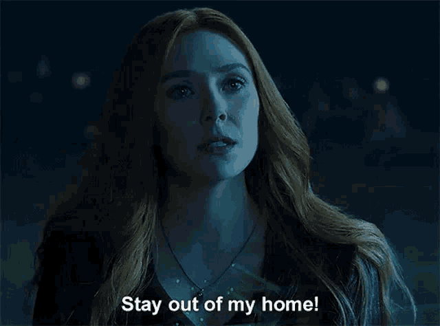 a woman in a dark room is saying stay out of my home .