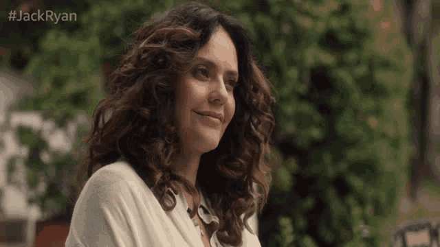 a woman with curly hair is smiling in front of a green background with the hashtag #jackryan