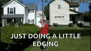 a man in a red shirt is walking down a sidewalk in front of a house .