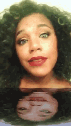 a woman with curly hair has a reflection of her face