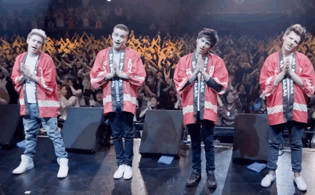 a group of young men wearing red kimonos with the letters aaa on them