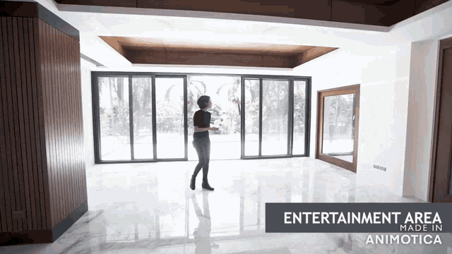 a woman stands in an empty room with the words entertainment area made in animotica