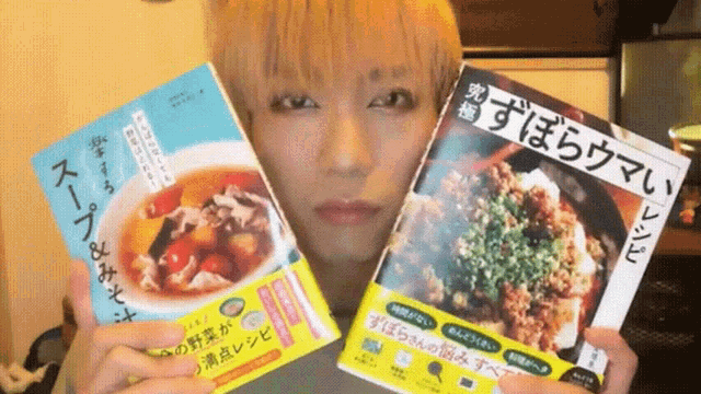 a man is holding two books one of which is written in a foreign language