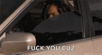 a woman is driving a car and covering her face with her hand .