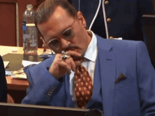 a man in a suit and tie is sitting at a desk