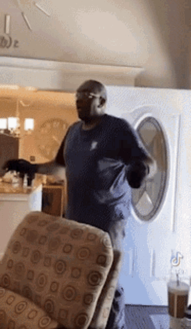 a man is dancing in a living room in front of a door