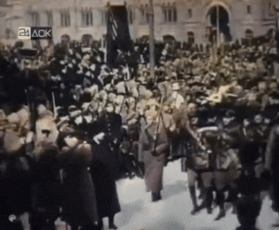 a crowd of people are gathered in front of a building with the number 24 ack on the bottom right