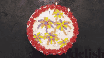 a birthday cake with candles on it and the word delish below it