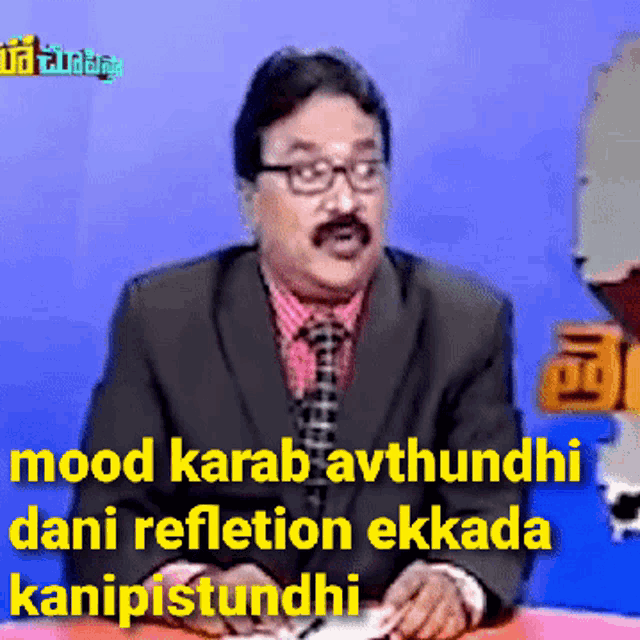 a man in a suit and tie is sitting at a desk with a caption that says mood karab avthundhi