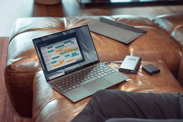 a person sitting on a couch with a dell laptop