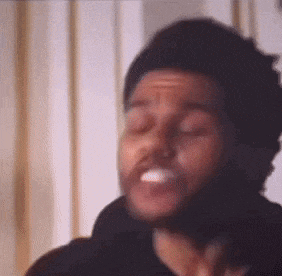 a man with a beard is making a funny face with his eyes closed and his mouth open .