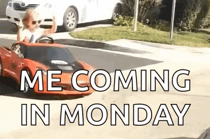 a man is driving a toy car down a street with the words `` me coming in monday '' .