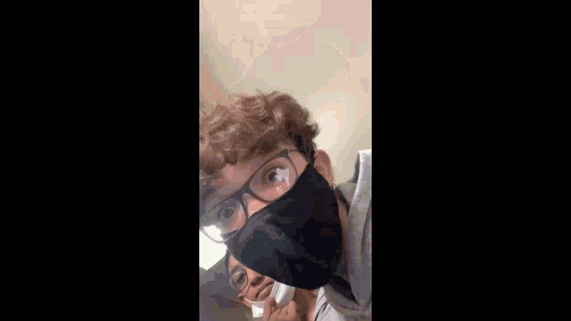 two boys wearing masks and glasses are standing next to each other in a hallway