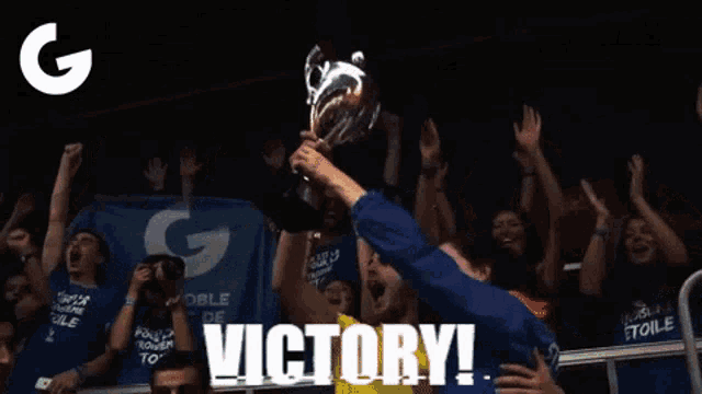 a man is holding a trophy in front of a crowd with the words victory written on the bottom