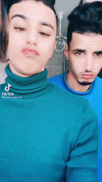 a man in a green turtleneck is next to another man
