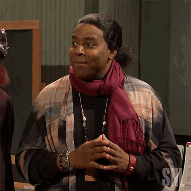 a man wearing a scarf and a shirt that says ' snl ' on the bottom