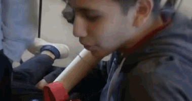 a close up of a person holding a piece of paper in their mouth .