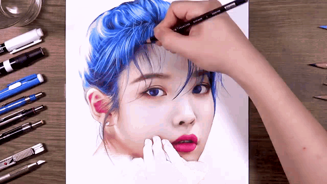 a person is drawing a woman with blue hair with a pencil that says prismacolor