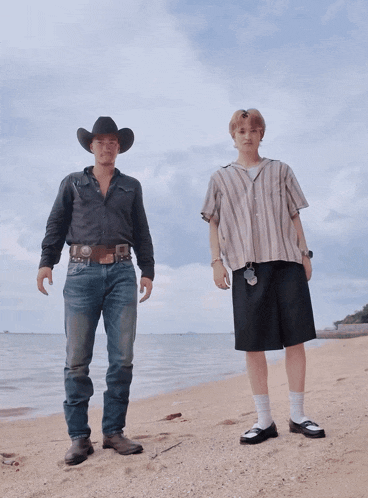 a man in a cowboy hat stands next to a man in a striped shirt