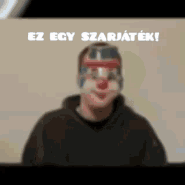 a man with a clown mask on his face and the words ez egy szarjatek written above him .