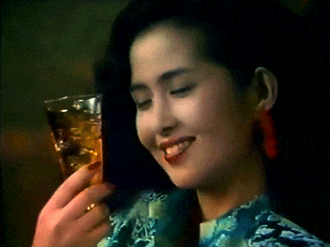 a woman holds a glass of liquid in her hand