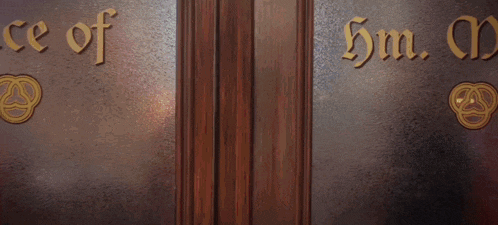 a woman with red hair is standing in a doorway with a sign that says ice of hm .