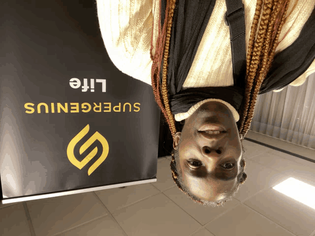 a woman stands upside down in front of a supergenius life sign