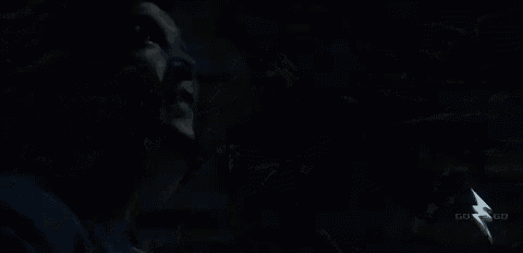 a woman is standing next to another woman in a dark room .