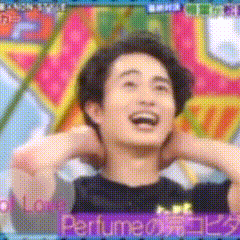 a man is laughing in front of a colorful background with the word perfume on it