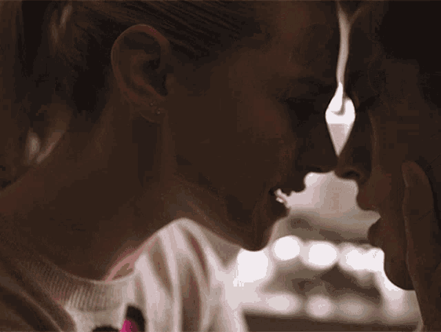 a close up of a woman kissing another woman 's forehead