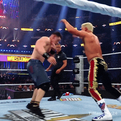two men are wrestling in a ring with a sign that says wrestlemania in the background