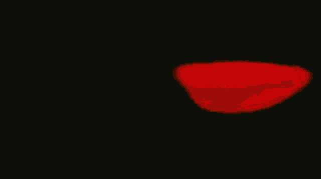 a red heart is being blown up by a fireball .