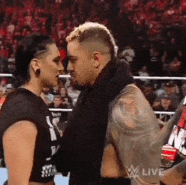 a man and a woman are standing next to each other in a ring .