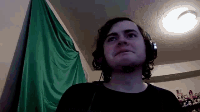 a man wearing headphones looks up at the ceiling