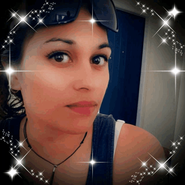 a woman wearing sunglasses and a necklace is surrounded by sparkling stars