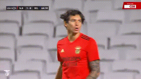 a soccer player in a red shirt is standing in front of a stadium .