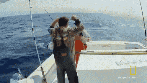 a man standing on a boat with a national geographic logo on the bottom