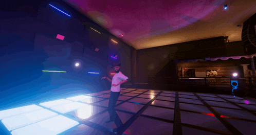 a man in a white shirt is dancing in a dark room with purple lights