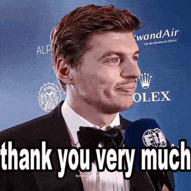 a man in a tuxedo is talking into a microphone with the words thank you very much below him