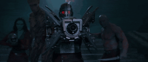 a man in a helmet is holding a gun that is shooting a red light .